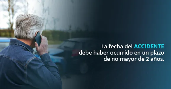 Hombre hablando por teléfono junto a vehículos tras un accidente de auto en Connecticut.
